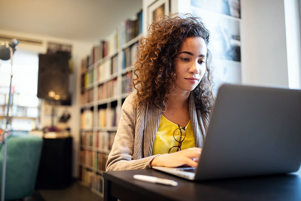 An adult learner working on a laptop during their studies